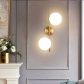 Applique da parete metallo oro con 2 sfere in vetro bianco attacco G9 lampada design moderno minimal